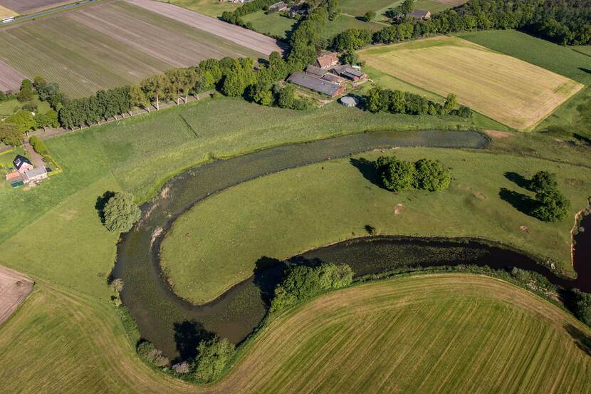 Akkerland met een meanderende rivier ertussen